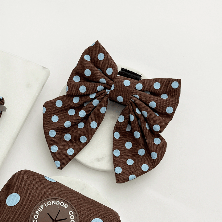 A brown dog sailor bow tie with light blue polka dot design. With velcro fastening.