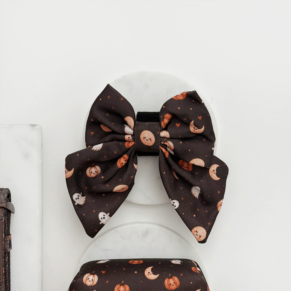 Brown dog sailor bow tie with cute Halloween print featuring pumpkins, ghosts, and moons.