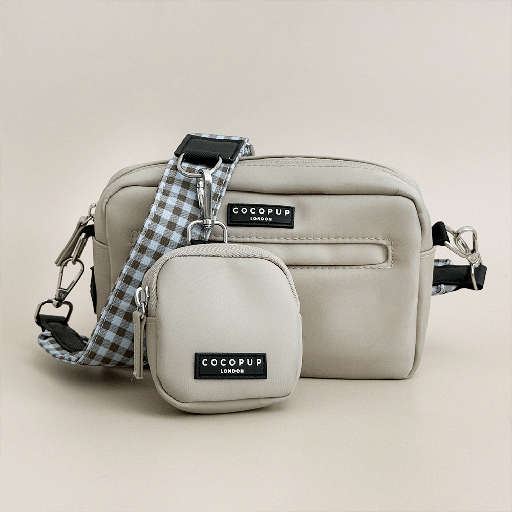 Beige Cocopup Dog Walking Bag with blue and brown bag strap attached. Also attached is a small pouch for dog treats.