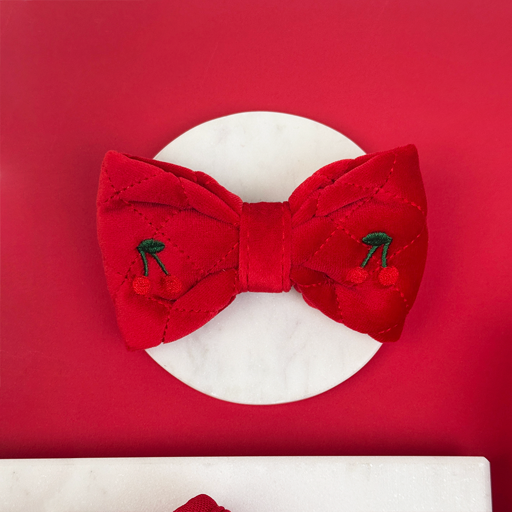 Red bow with cherry details on a white background