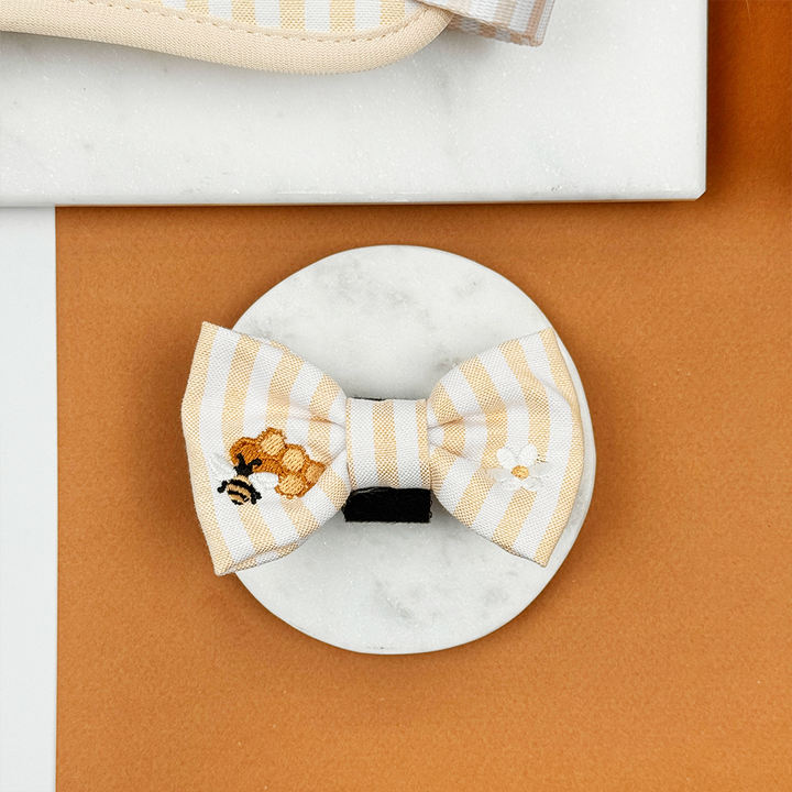 Pale yellow and white striped Dog Bow Tie with bee and honeycomb embroidered decals. 