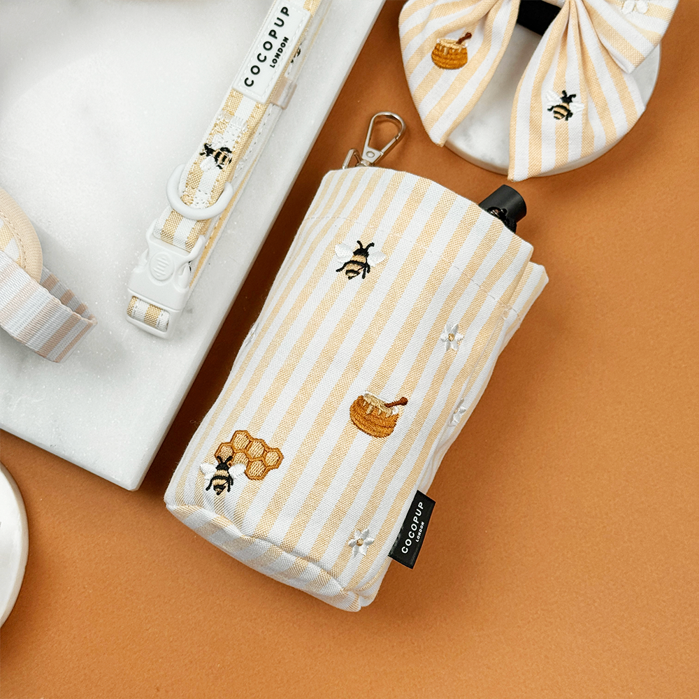 Pale yellow and white striped Drawstring Treat Pouch with bee and honeycomb embroidered decals. 