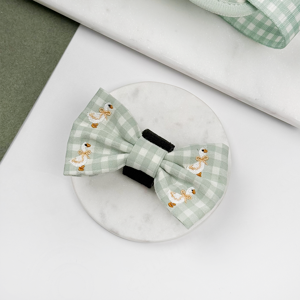 Green and white check print dog bow tie with embroidered geese design.