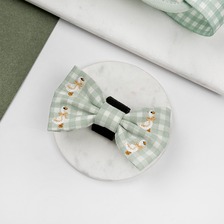 Green and white check print dog bow tie with embroidered geese design.