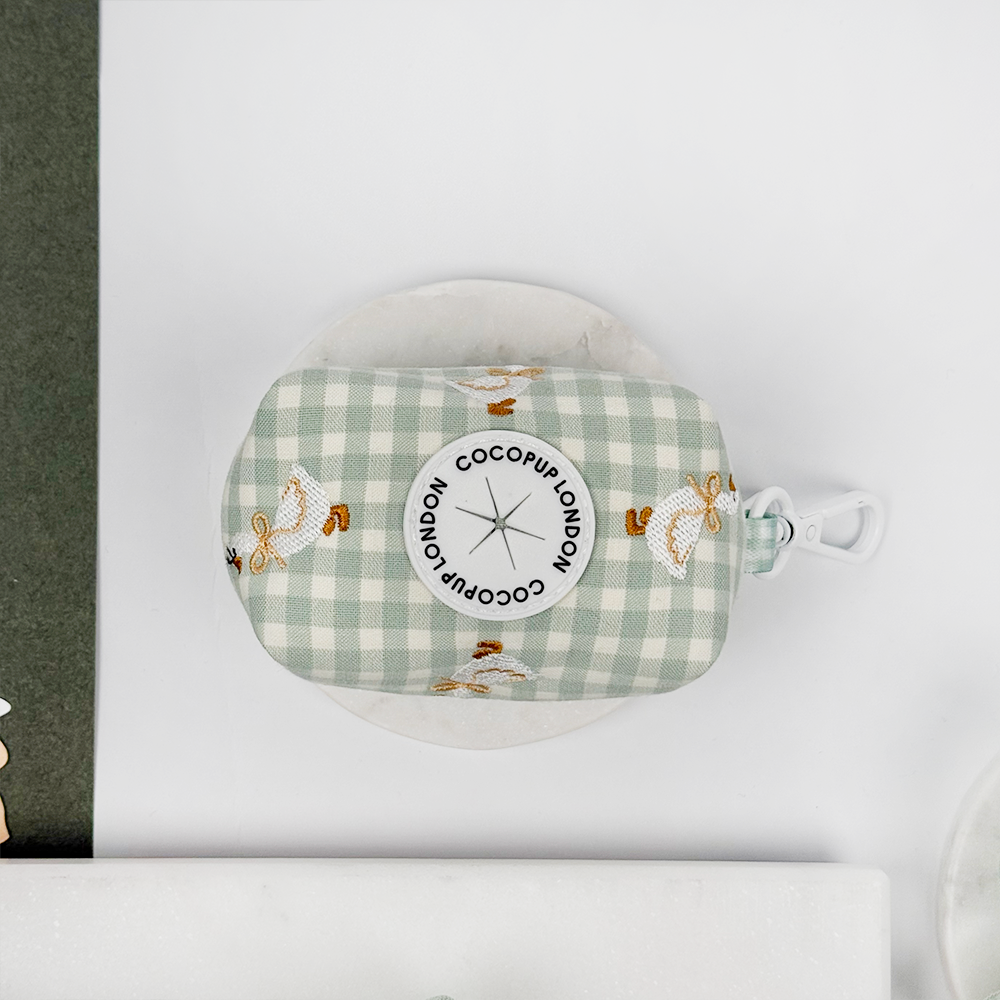 Green and white check print poop bag holder with dispenser with embroidered geese design.