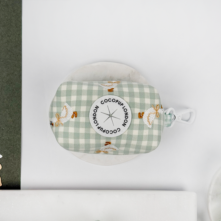 Green and white check print poop bag holder with dispenser with embroidered geese design.