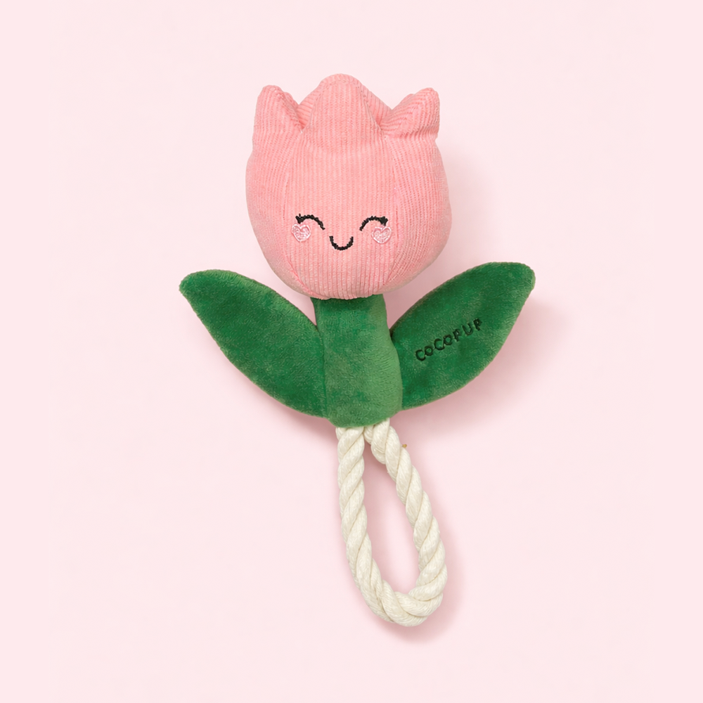 Pink tulip-shaped toy with a rope on a light pink background.