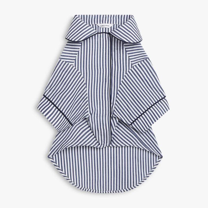 A striped dog shirt PJS with a collar and short wide sleeves, featuring vertical navy and white stripes with thin navy piping details, shown on a light gray background.