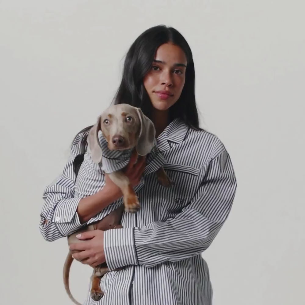 women and dog in matching navy and white striped pjs
